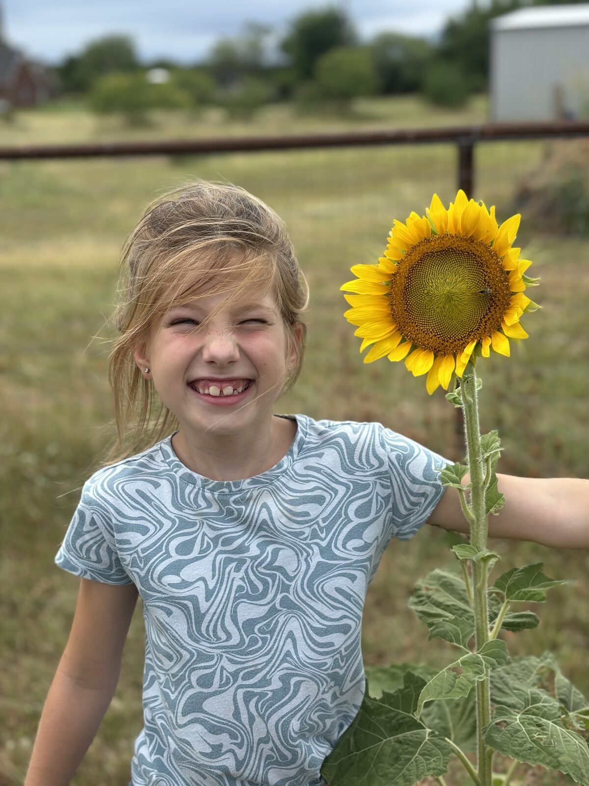 Alexi, Brinlee's sister, outdoors with a sunflower